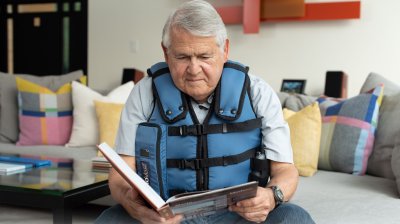 man reading a book wearing an afflovest