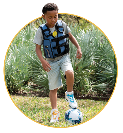 boy playing soccer with afflovest on